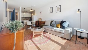 Ein modernes Wohnzimmer mit Sofa, Couchtisch und einem Essbereich mit Stühlen und einem Tisch.