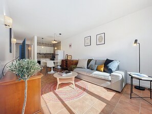 Ein modernes Wohnzimmer mit Sofa, Couchtisch und einem Essbereich mit Stühlen und einem Tisch.