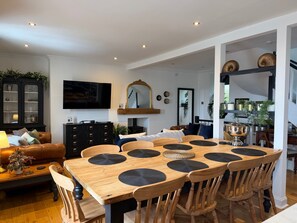 A dining area with a wooden table, chairs, and a black cabinet. - Sea View 4-bed Townhouse, Sleeps 7 in Anstruther (Anstruther)
