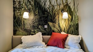 A bed with a patterned bedspread, two pillows, and a red accent pillow. - Holiday Home Sommergrün with Garden (Nordwestuckermark)