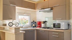 Uma cozinha moderna com uma bicicleta, uma cafeteira e um micro-ondas.