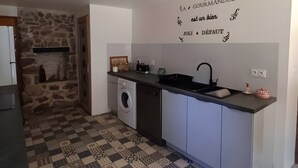 Een moderne keuken met een stenen muur, een wasmachine en een vloer met een patroon.