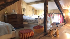 Een gezellig zolderkamer met houten wanden, een bed, een kaptafel en een pluchen hondenspeeltje.