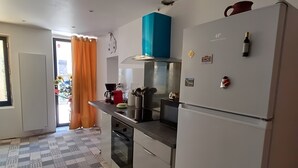 Een keuken met een vloer met een patroon, een koelkast, een magnetron en een fornuis.