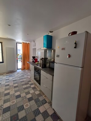 A kitchen with a patterned floor, a refrigerator, a microwave, and a stove. - Traditional Mountain House with View, Private Terrace and Garden in Ercé (Ercé)
