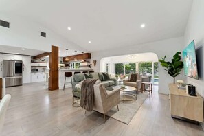 A spacious living area with a modern kitchen, a sofa set, and a coffee table. - Lighthouse Luxury Escape w/ Pool & BBQ (Lighthouse Point)