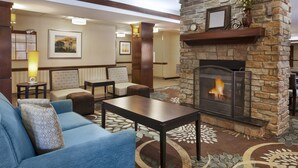 A hotel lobby with a stone fireplace, seating area, and a carpeted floor. - 1BR Suite w/ Fireplace & Kitchen + Breakfast | Near Mizzou (Columbia)