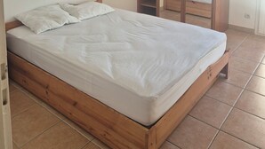 A bedroom with a wooden bed frame, a white mattress, and a large wardrobe with a mirror. - Large family home - 4 bedrooms, enclosed garden & terrace (Sainte-Radegonde)