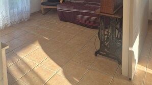 A living room with a sofa, a chair, a table, and a ceiling light fixture. - Large family home - 4 bedrooms, enclosed garden & terrace (Sainte-Radegonde)