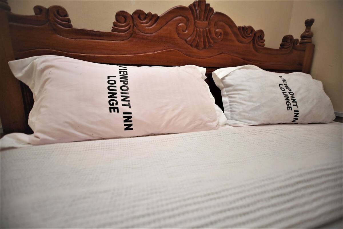 Una cama con dos almohadas que dicen "VIEWPOINT INN LOUNGE".