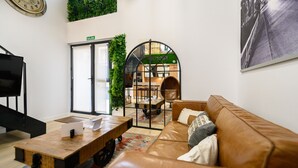 Ein modernes Interieur mit einem Ledersofa, einem Holztisch und einem Fernseher.