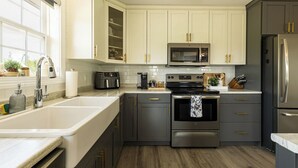 A modern kitchen with a stainless steel refrigerator, a built-in oven, a microwave, and a sink.