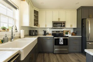 A modern kitchen with a stainless steel refrigerator, a built-in oven, a microwave, and a sink.