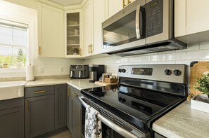 Eine moderne Küche mit eingebautem Backofen, Mikrowelle und Kaffeemaschine.