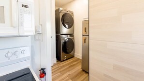 Ein Waschraum mit Waschmaschine, Trockner und Kühlschrank.