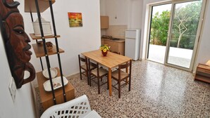 Une cuisine compacte comprenant une table à manger, une chaise en bois et une petite étagère.