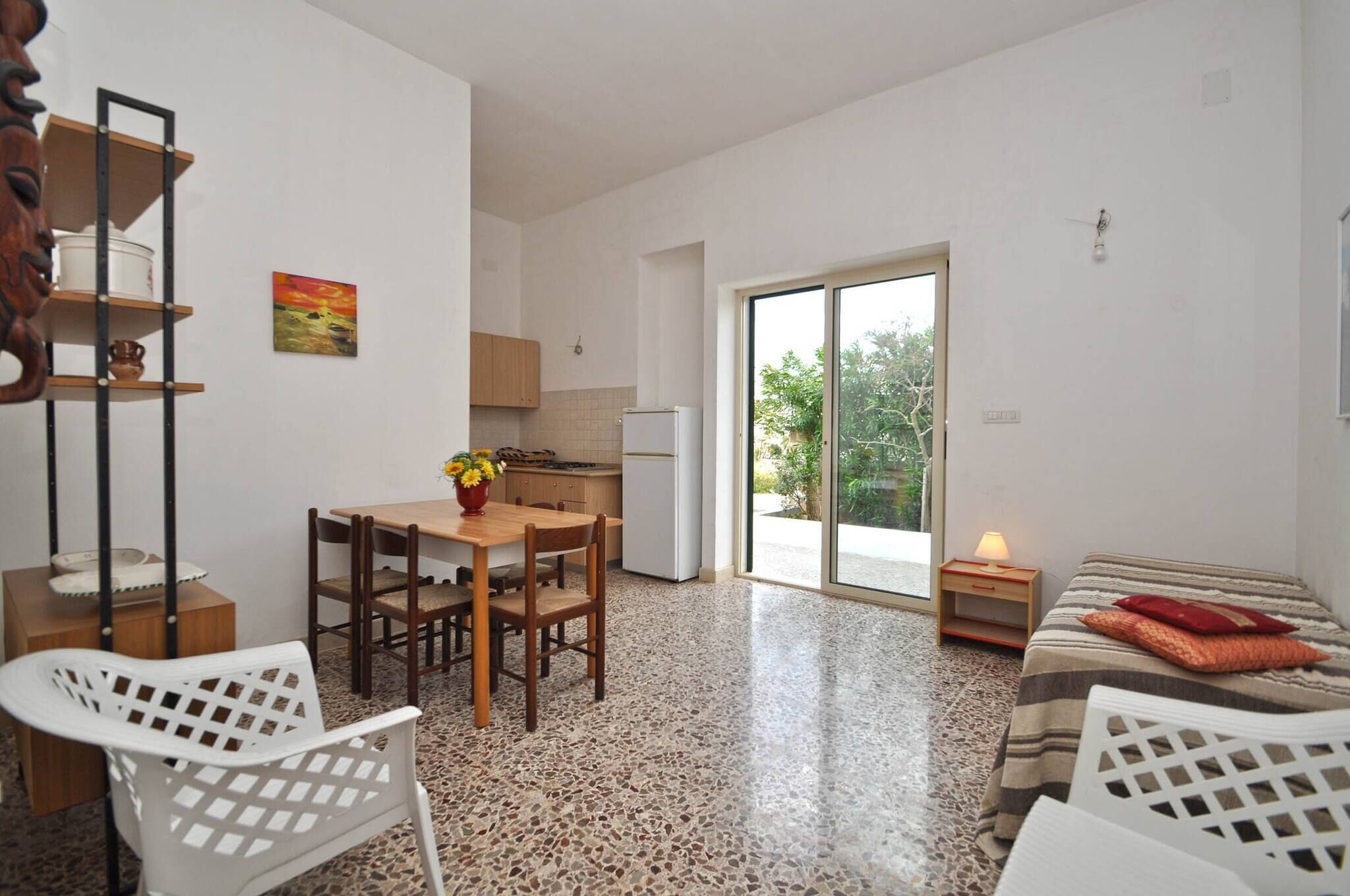 A compact living space with a dining area, kitchenette, and a bed.