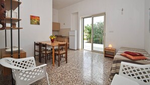 Un espace de vie compact comprenant un coin repas, une kitchenette et un lit.