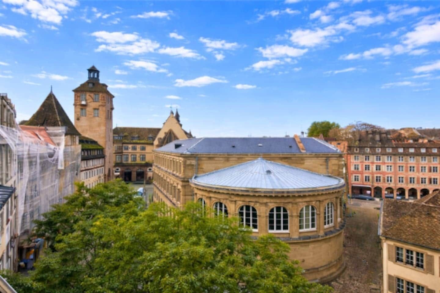 Een historisch gebouw met een centrale koepel en een toren, omgeven door andere traditionele architectuur.