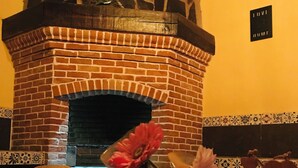 A brick fireplace with a stone top, a table with a 'Flowers & Garden' sign, and a 'Love' sign on the wall. - CASA CABERNET ideal location for building memories (Parras de la Fuente)