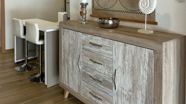Una cocina moderna con un armario de madera, un mapa en la pared y un equipo de aire acondicionado.