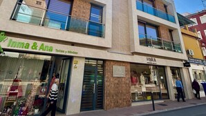 A multi-story building with a storefront labeled 'Inma & Ana' and 'HRA' on the ground floor.