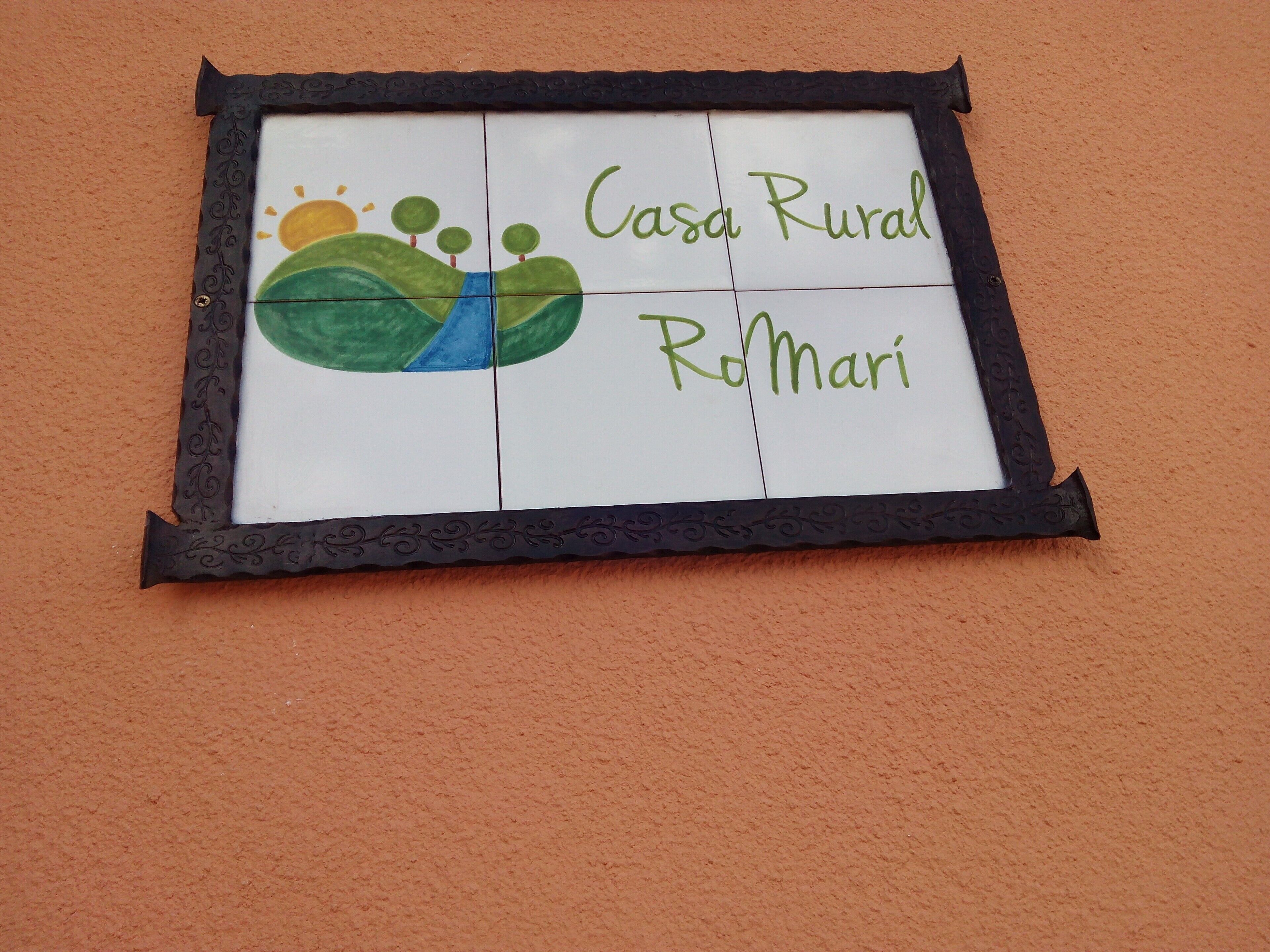 A framed sign with a landscape design and the text 'Casa Rural Romari'.