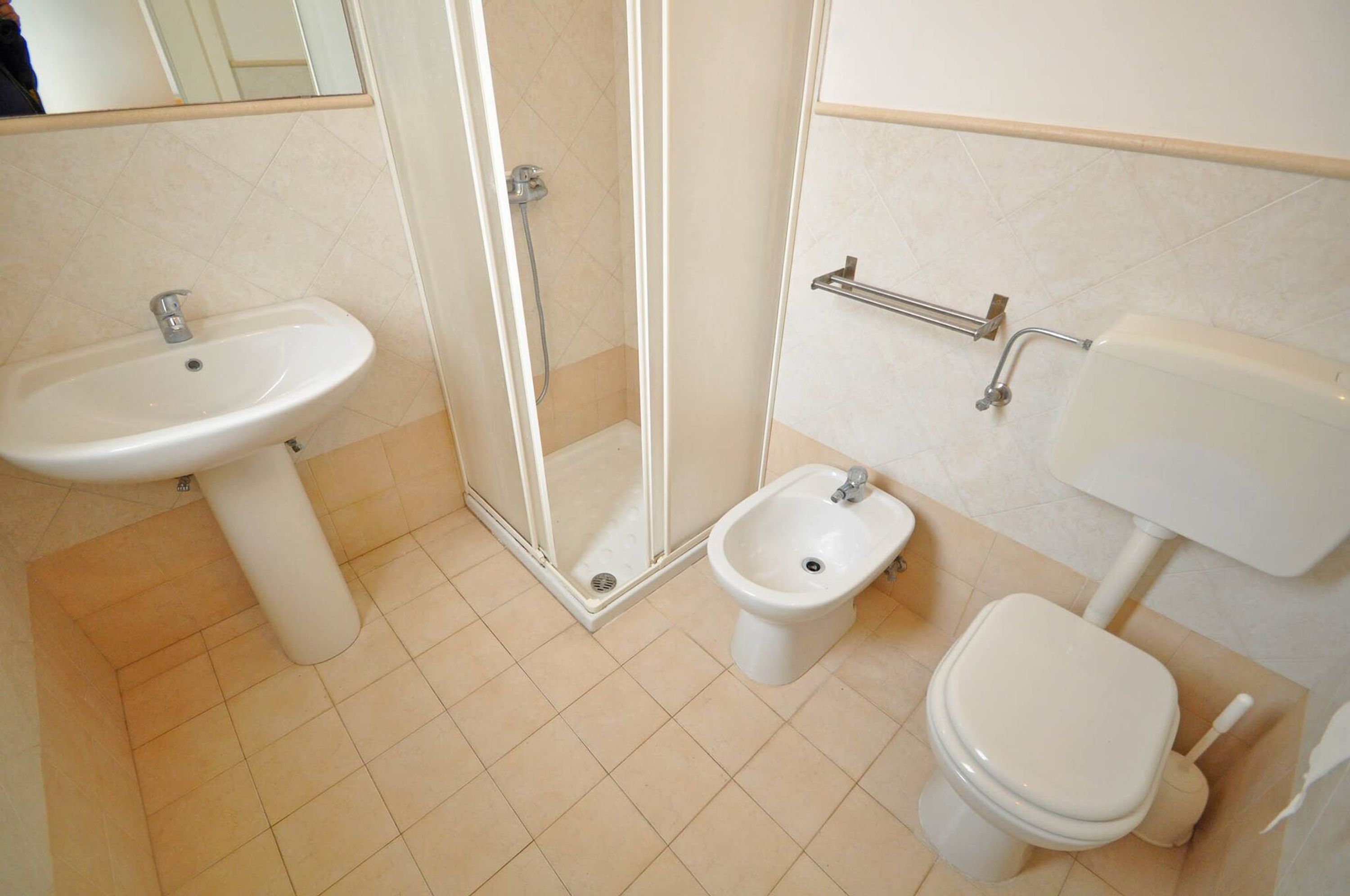 Une salle de bain équipée d’un lavabo, d’un bidet, de toilettes et d’une douche à parois de verre.