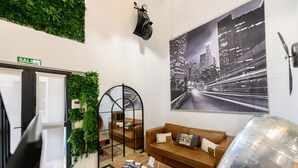 A modern living room with a sofa, coffee table, and a large cityscape poster. - M Alg310b Amplio y Moderno Loft con Terraza Priv (Madrid)