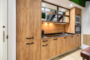 A kitchen with wooden cabinets, a stainless steel sink, and a microwave. - M Alg310b Amplio y Moderno Loft con Terraza Priv (Madrid)