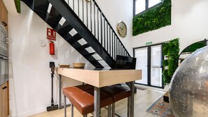 A modern interior with a staircase, a fire extinguisher, a clock, and a door labeled "SALIDA". - M Alg310b Amplio y Moderno Loft con Terraza Priv (Madrid)