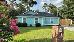 A single-story house with a gabled roof, a front porch, and a brick mailbox. - Tropical Funky Oasis- near downtown and islands. Pet Friendly! (Savannah)