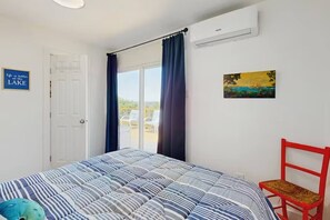 Une chambre à coucher avec un lit, une chaise, un tableau et une porte.