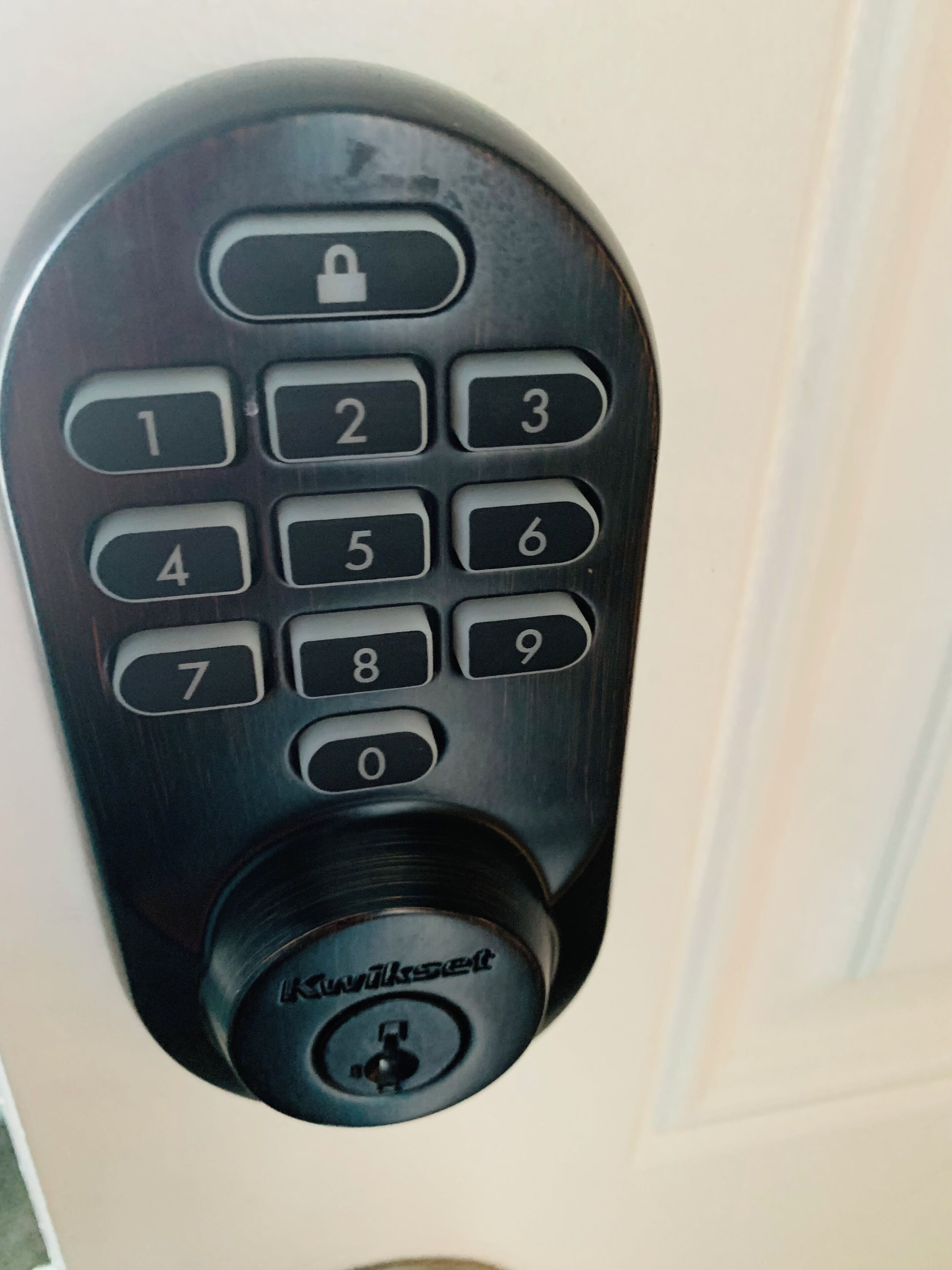 A numeric keypad lock with a keyhole below it.