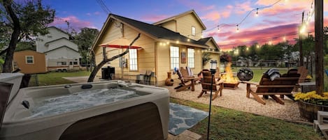 A house with a hot tub, outdoor seating, and a fire pit.