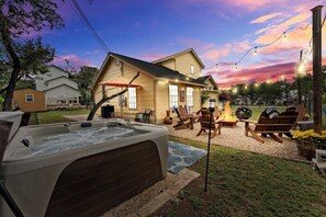 A house with a hot tub, outdoor seating, and a fire pit.