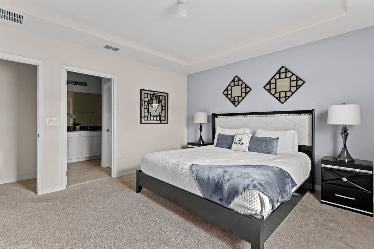 A bedroom with a bed, bedside tables, and a nightstand.