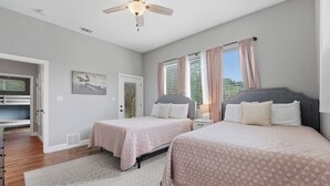 A bedroom with two beds, a ceiling fan, a door leading to a balcony, and a window with blinds. - Family Friendly! Firepit, Cornhole, & 3 Lg Decks (Canyon Lake)