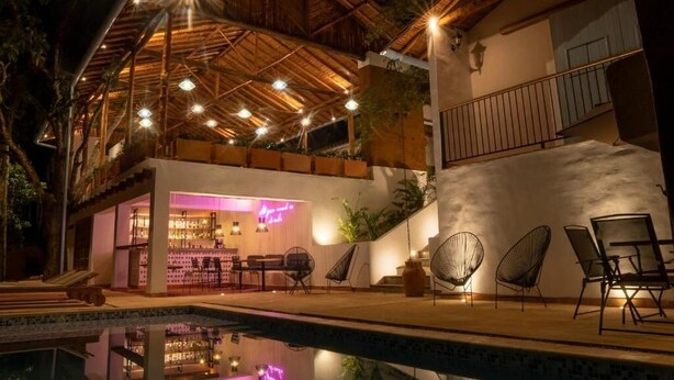 A poolside area with a bar, outdoor seating, and a covered patio. - CASA GUATI (Barichara)