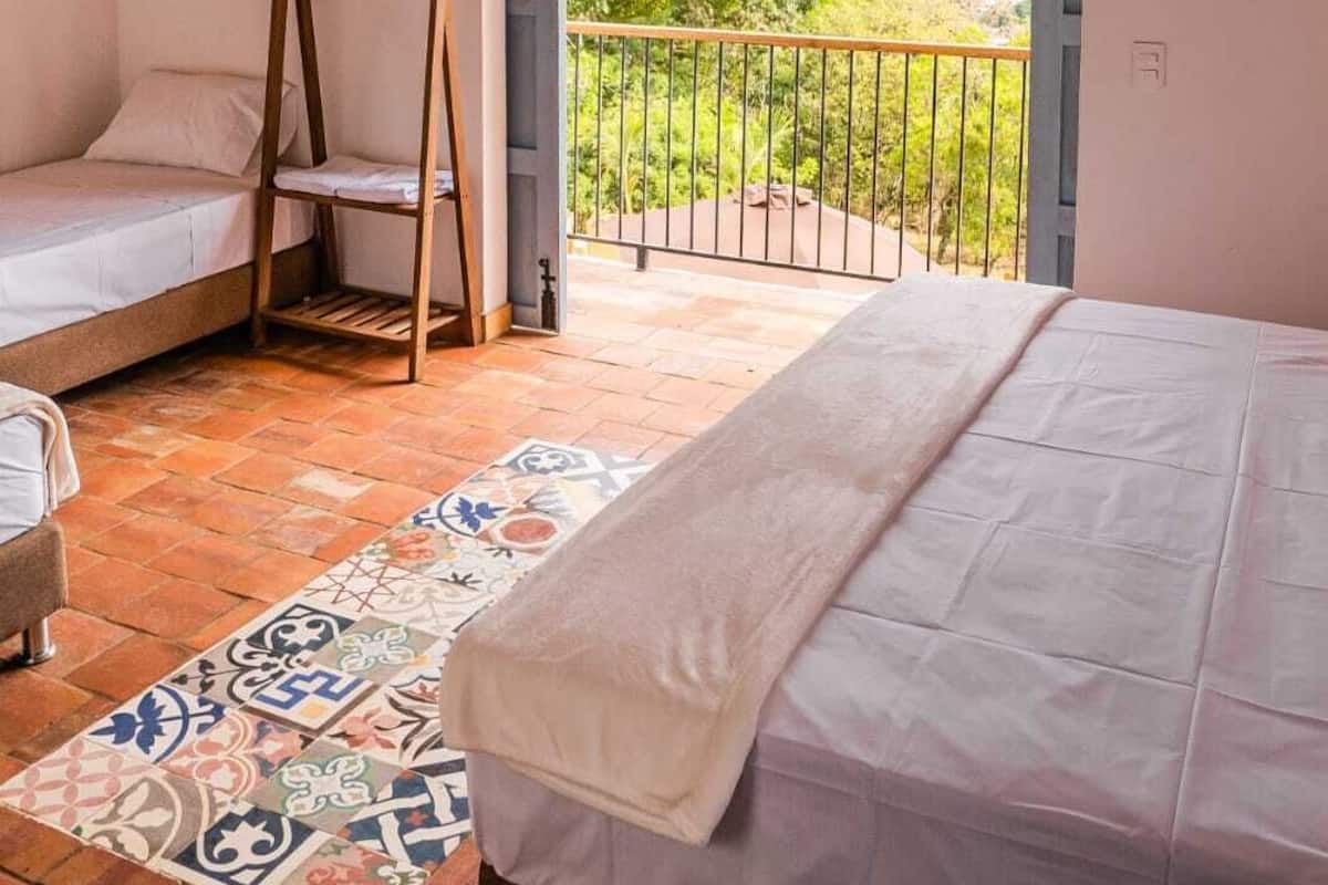 Un dormitorio con balcón, una escalera de madera y un tapete estampado.
