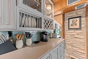 A kitchen with grey cabinets, a coffee maker, and utensils on the counter. - Sleeps 14 on the River! Free Kayaks -by Whitewater (Canyon Lake)