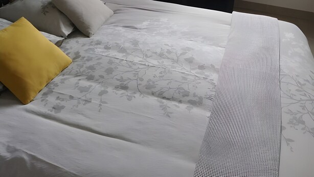 Une chambre à coucher avec un lit, une bibliothèque, une chaise et une fenêtre.