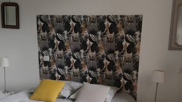 Une chambre à coucher moderne avec un grand lit, une tête de lit à motifs, une table de chevet et une chaise.
