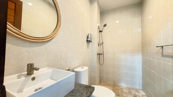 A bathroom with a sink, toilet, and shower. - Moonlight Sanur (Denpasar)