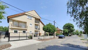 A multi-story residential building with balconies, a gated entrance, and a clear street. - Spacious 6-bedroom apartment in welcoming Budapest with AC (Budapest)