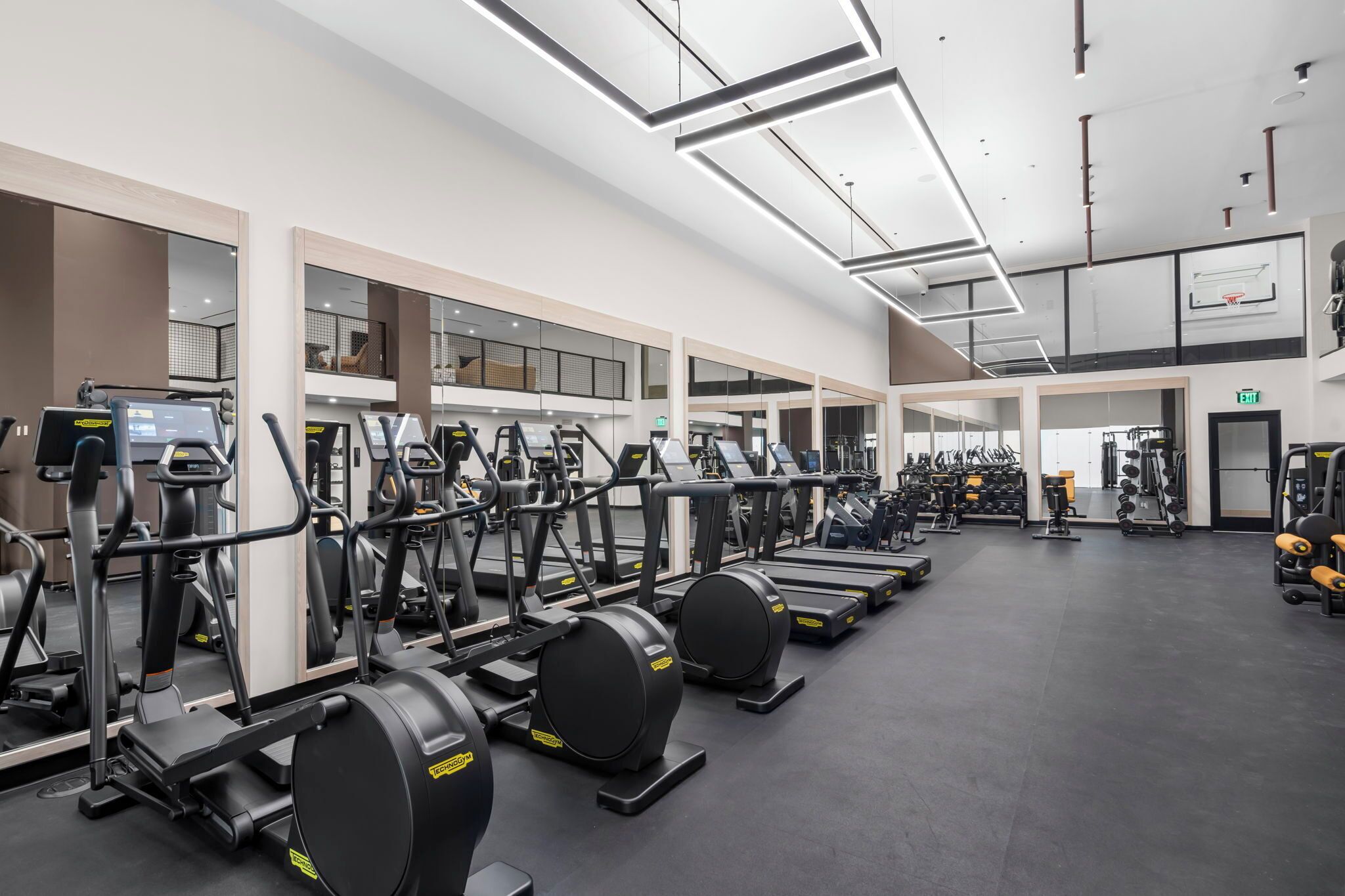A gym with multiple treadmills, stationary bikes, and weight machines.