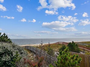 Blick auf die Küste mit einem Holzsteg, Strand und Meer.