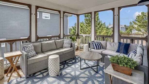 A covered patio with a sofa, coffee table, and potted plants. - 5BR Beach Home | Steps to Ocean | Sleeps 12! (North Bethany Beach)