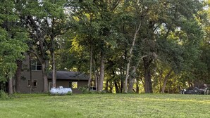 A house surrounded by trees with a grassy yard.