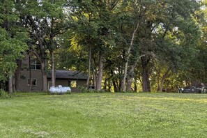 A house surrounded by trees with a grassy yard. - Family Nature Haven! Waterfront Pelican Lake Home (Ashby)